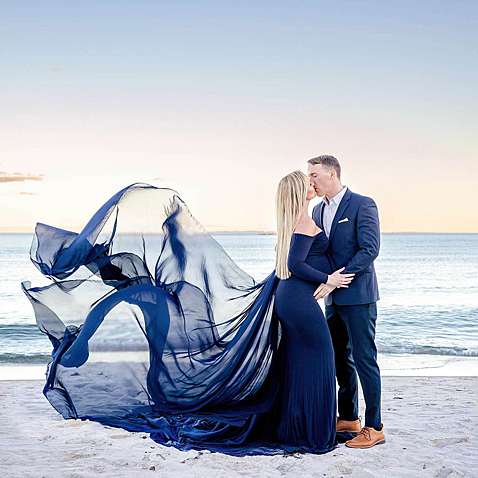 A maternity couple at the beach wearing dark navy at sunset in Niantic Connecticut.